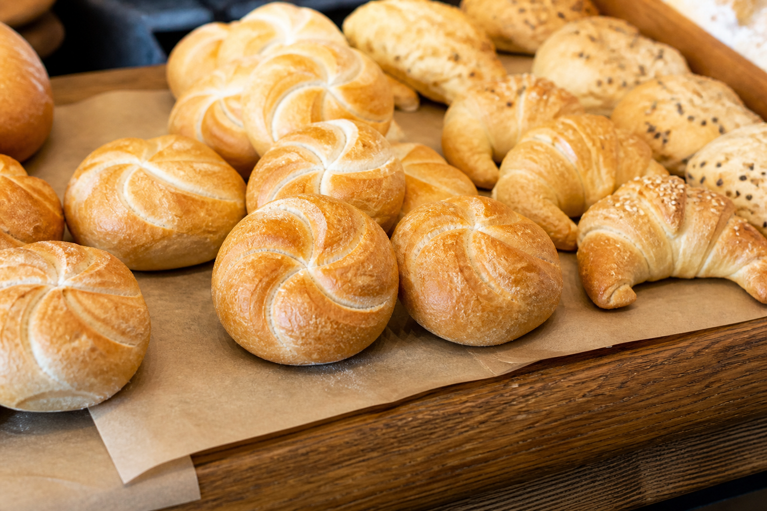 Golden Kaiser rolls on parchment in the bakery